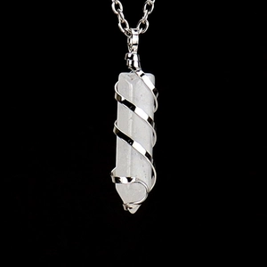 Detailed close-up of a hexagonal white quartz crystal pendant with silver spiral wire wrap