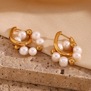 Détail de boucles d'oreilles en U plaquées or 18K avec d'élégantes perles d'eau douce