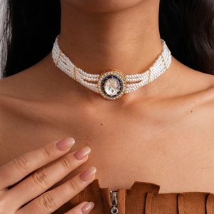Detailaufnahme des mehrlagigen Perlen-Chokers mit blauem Strass-Anhänger auf dem Hals
