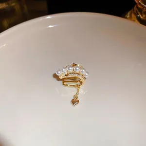 Gold plated heart ear cuff with layered zircons and pearls on elegant chain tassel
