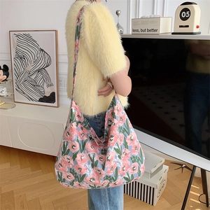 Detail of floral canvas tote bag showing pink flower patterns and casual hobo style
