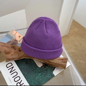 Detailed close-up of a purple knitted beanie featuring premium ribbed wool texture