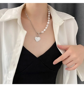 Close-up of pearl and silver chain necklace with heart pendant and T-bar toggle clasp