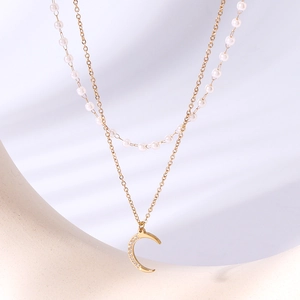 Double-layer gold necklace with white faux pearls and a sparkling moon pendant