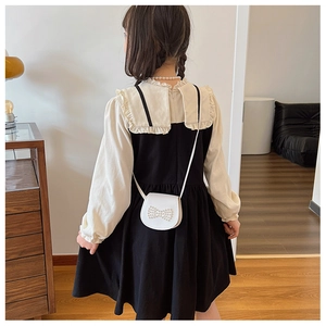 Detail view of the back design on the beige ruffle collar shirt and black dress set