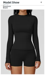 Detail of slim fit black long sleeve yoga top and high-waist shorts set for gym training