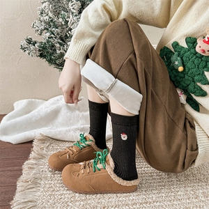 Détail de bottes d'hiver en daim marron avec lacets verts et doublure en peluche chaude