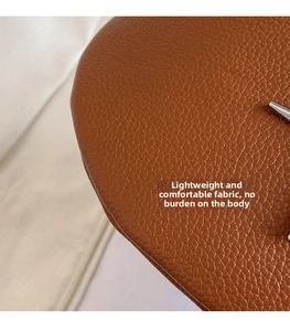 Close-up of brown litchi grain leather texture showing high quality material and stitching