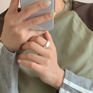 Macro detail of minimalist S925 silver North Star ring on finger in a mirror selfie