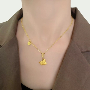 Golden rabbit necklace featuring a luck pendant and small round charm on model