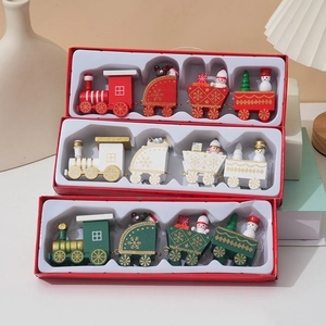Three colorful wooden Christmas train sets in gift boxes for holiday tabletop decoration