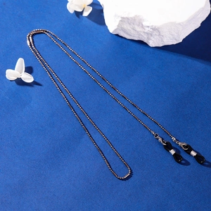 Fashionable dark gunmetal beaded glasses chain with rubber loops on a textured background