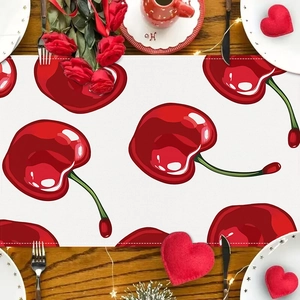 Linen table runner with red cherry pattern on wooden table with romantic decor