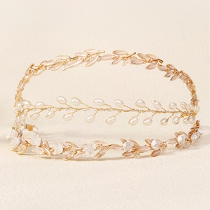 Close-up of baroque bridal headband featuring gold metal leaves, white pearls and flowers
