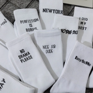 White crew socks with black letter print and ribbed knit for a street style look