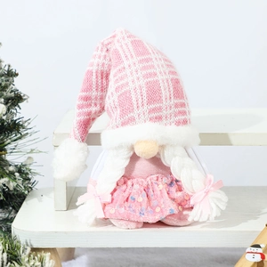 Close-up of pink Christmas gnome with sequin skirt and plaid hat on wooden stand