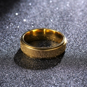 Macro shot of 6mm matte gold titanium steel ring with polished edges on dark background