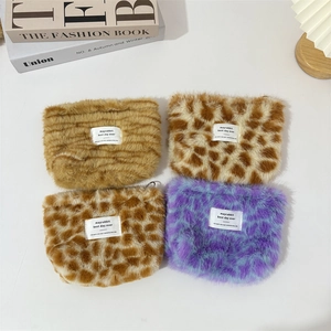Close-up of four plush leopard print makeup bags in various colors with white woven labels