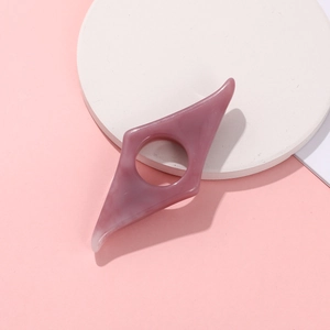 Pink resin thumb book holder for reading assistance with smooth marble texture finish