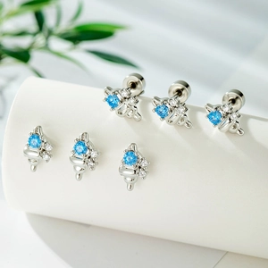 Blue zircon conch earrings in silver metal with small clear stones on white surface