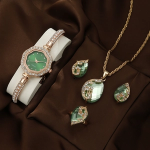 Detailed set showing gold quartz watch with green gems, necklace, earrings, and ring