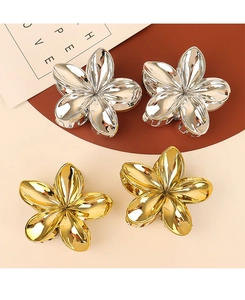 Macro shot of gold and silver flower hair claws with a high-shine metallic mirror finish