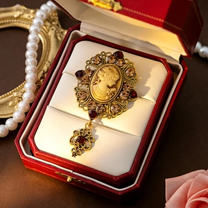 Detail of vintage cameo brooch with red rhinestones in a luxury jewelry box