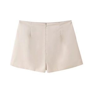 Vista dettagliata di pantaloncini beige a pieghe con cerniera invisibile su sfondo piatto