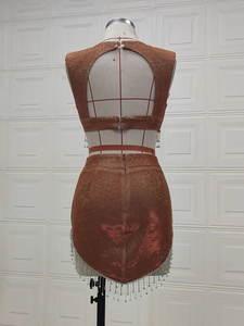 Dettaglio posteriore del set marrone con paillettes e frange su un manichino sartoriale
