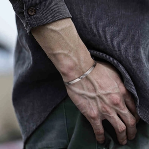Close-up of 4.5mm flat snake bone silver bracelet on male wrist for a minimalist style