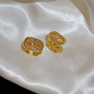 Macro shot of 18k gold plated V-logo earrings with shimmering zircon pavé stones