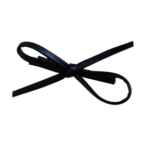 Minimalist Y2K black faux leather bow hair clip with glossy texture on white background