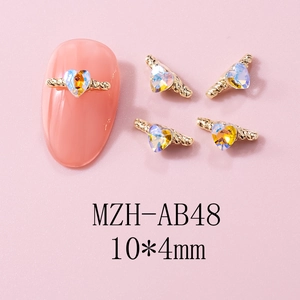 Detail of 10x4mm gold heart nail charm with AB rhinestones on a pink nail tip