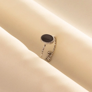 Minimalist silver-toned stainless steel ring with black enamel oval detail and textured band