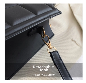 Close-up of black padded quilted leather texture and golden detachable hardware hook