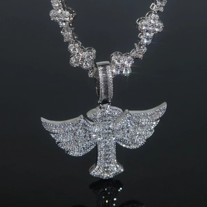Close-up of silver hip hop necklace featuring iced-out cross and angel wings pendant