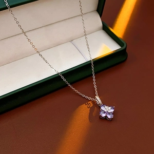 Détail du collier trèfle avec pierres violettes et diamants dans un écrin vert luxueux