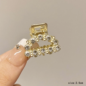 Detail of 2.5cm gold rhinestone hair claw clip showing precise size and sparkling finish