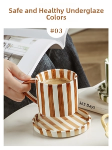 Detailed view of hand-painted brown stripe ceramic coffee cup and saucer set on marble