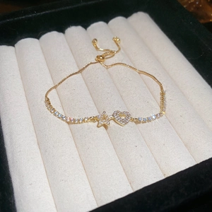 Detail of adjustable gold bolo clasp on cubic zirconia star and heart charm bracelet