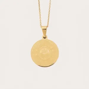 Collier avec pendentif rond doré et calligraphie arabe sur fond crème minimaliste