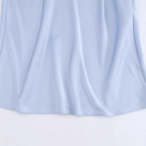 Close-up of a light blue satin dress hem featuring glossy fabric and elegant draping