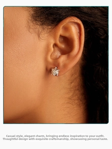 Macro shot of silver luminous turtle stud earrings on ear with detailed shell inlay