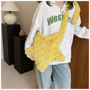 Detail of plush star-shaped crossbody bag in bright yellow faux fur with wide shoulder strap