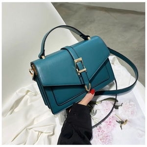 Detail view of dark green PU leather crossbody bag with elegant gold hardware buckle