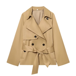 Detail of short khaki trench coat featuring classic double-breasted black buttons and tied belt