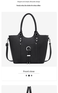 Detail of black tote bag with matte texture, silver hardware and double tassels