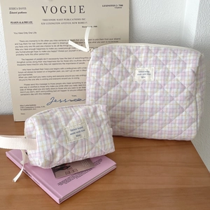 Close-up of pink and yellow quilted checkered makeup bags with high-quality zipper detail