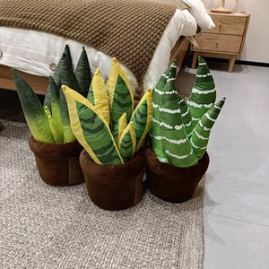 Trois peluches de fleurs en pot aux motifs variés posées sur un tapis tissé cosy