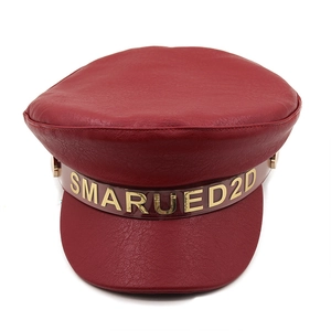 Dettaglio della texture in pelle PU bordeaux e lettere metalliche dorate sul berretto